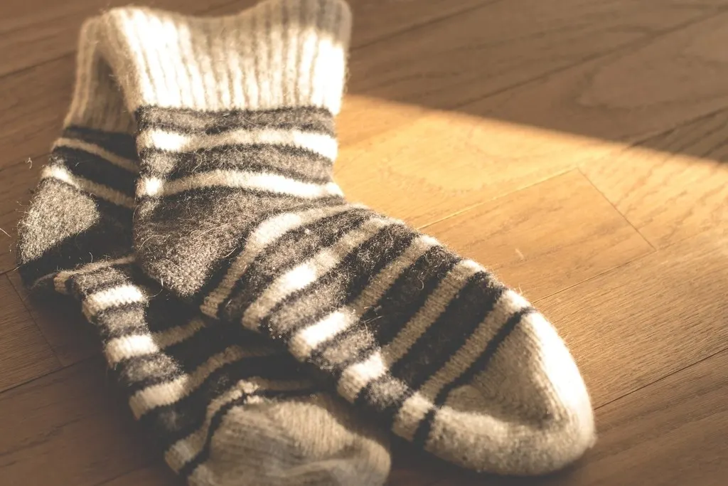 Striped wool socks on a sunlit wooden floor